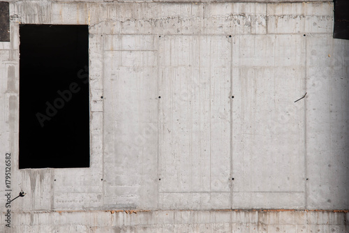Concrete Wall Frame of Building under Construction with Formwork Prints Smudges on Surface. Architectural origin of Structure. Monolithic box with window holes and floor slabs at Construction Site.
