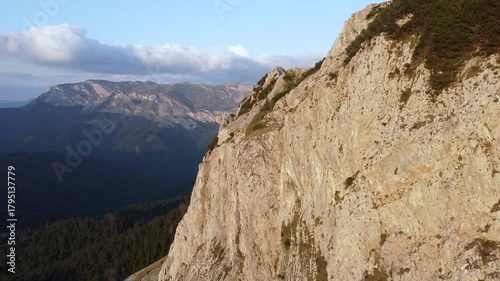 High cliffs on the mountain, aerial drone view. Rocks in nature. Steep rocks on the mountain at sunset. 