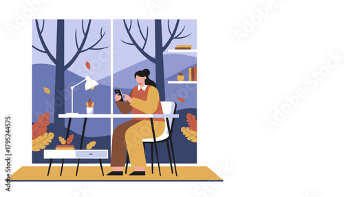 Woman works remotely on phone at her cozy autumn home office desk overlooking nature view