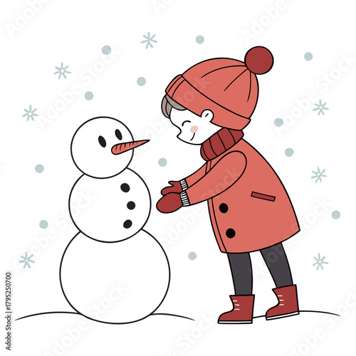 Child happily building a snowman in the snow