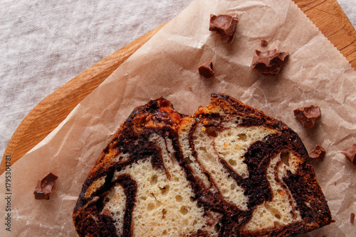 slice of marble cake with chocolate swirl on parchment paper, rustic dessert, wooden background