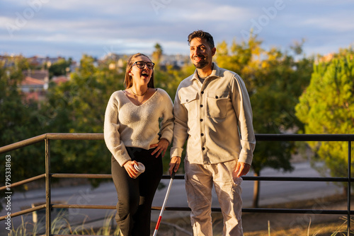 Happy couple laughing outdoors with visually impaired man