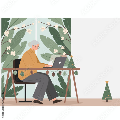 Senior woman working remotely on laptop with festive Christmas decorations