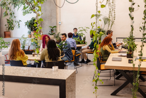 Diverse professionals working and collaborating in modern biophilic office