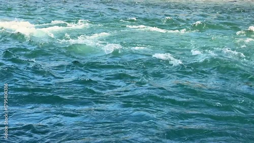 Fast river water flowing quickly with bright white foamy waves