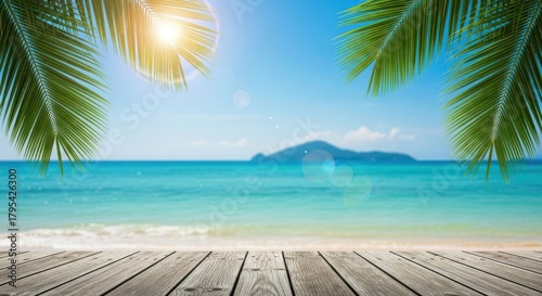 Idyllic tropical beach scene with a wooden deck in the foreground, turquoise ocean, clear blue sky, and lush palm leaves framing the view of a distant island