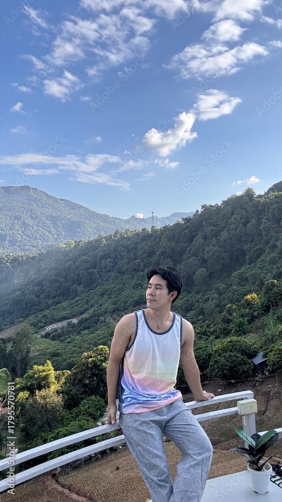 Naklejka premium Handsome Man Relaxing on a Camping Trip with Scenic Green Mountain View