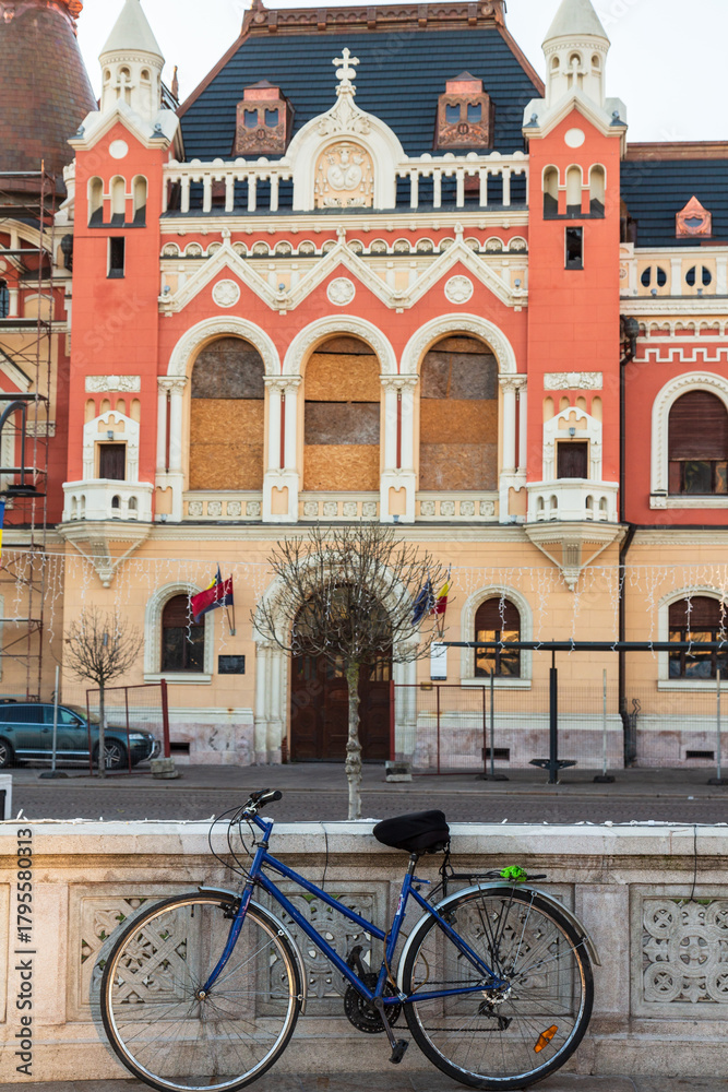Naklejka premium Oradea, Romania - 29 December 2019: Bicycle and Town hall square (Piata Unirii) with a building in Art Nouveau style of the town hall