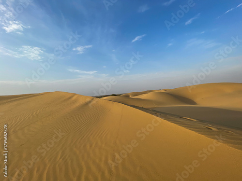 Wallpaper Mural Golden sand dunes of Jaisalmer under a bright blue sky, showcasing the vast and serene Thar Desert landscape with natural patterns and soft evening light. Torontodigital.ca