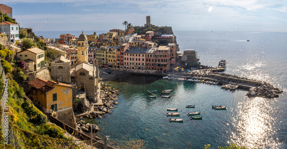 Obraz premium High panoramic view of Vernazza from the trail to Monterosso al Mare, showing the entire village perched on the rocks and the horseshoe-shaped harbor. Cinque Terre, Italy