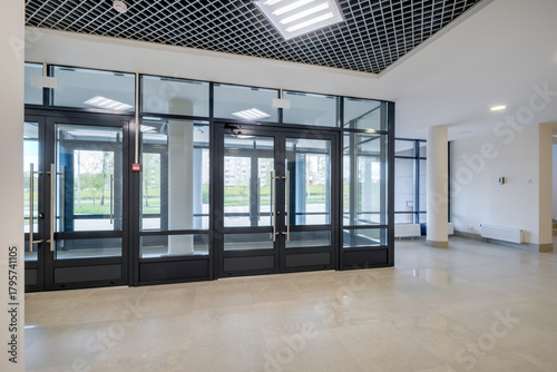 Fototapeta Naklejka Na Ścianę i Meble -  Glass entrance doors to a modern spacious office, view from inside the room