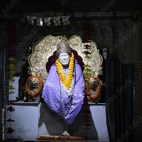 Sacred Sai Baba Statue Draped in Purple Cloth and Flower Garland