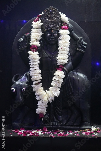 Shani Dev Black Stone Idol Decorated with Flowers
