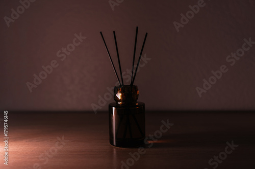 Luxury aroma diffuser standing on a wooden surface in soft warm light. Elegant home decor item creating a cozy, expensive and sophisticated atmosphere