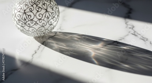 Elegant Decorative Sphere Casting Intricate Shadow on Marble Surface.