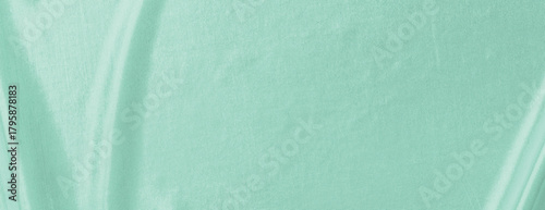 Mint green background with a smooth, fabric-like texture. The background is mint green, adding a soft, elegant touch. Minimal abstract gradient curve vector background