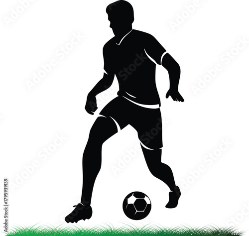Silhouette of soccer player dribbling ball on green grass