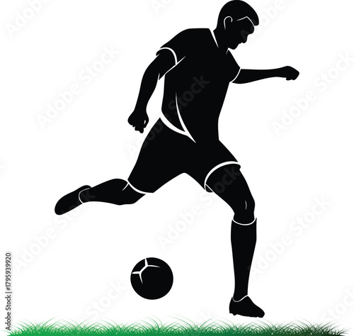 Silhouette of soccer player kicking ball on grass field
