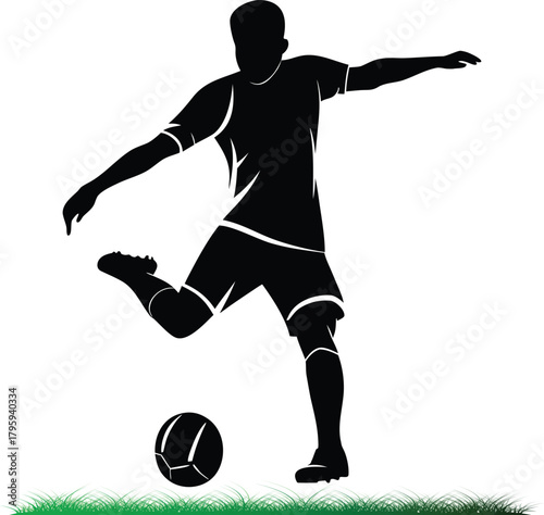 Silhouette soccer player kicking ball on green grass field