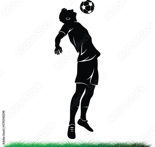 Soccer player heading ball silhouette in the grass