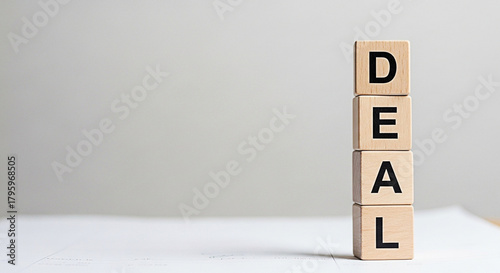 Wooden blocks stacked vertically spell out the word deal against a neutral background ideal for business and negotiation concepts