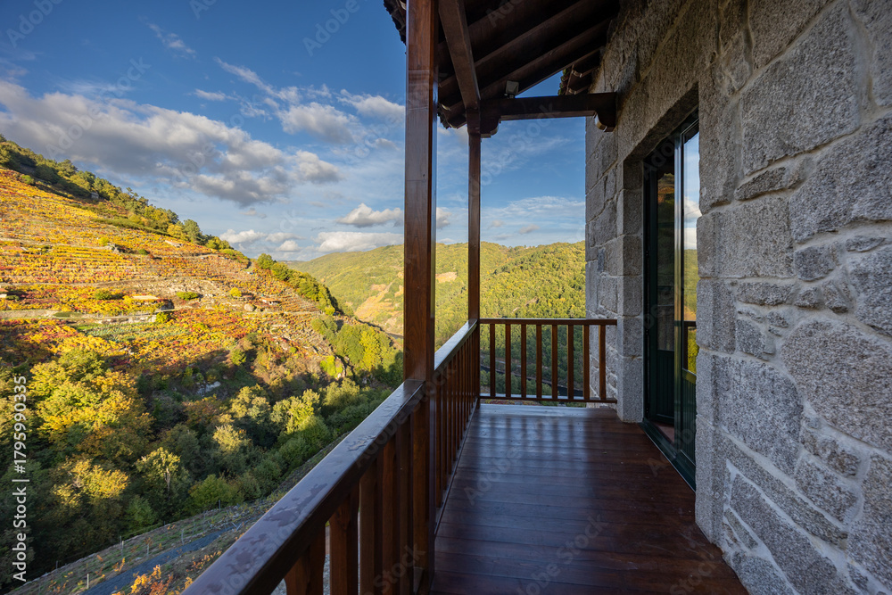 Naklejka premium Rustic stone house balcony overlooking douro valley vineyards