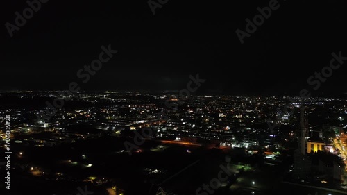 A stunning night panorama of the vast, brightly lit city from above, a dazzling tapestry