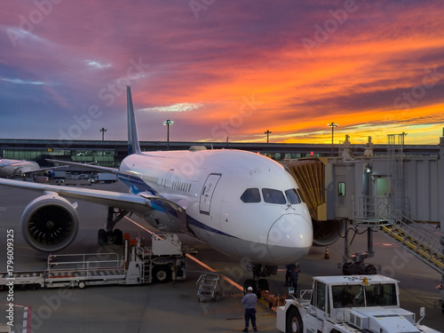 Photography Long-haul passenger jet waiting at the gate at sunset