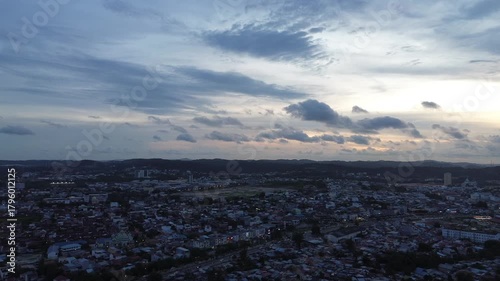 Panoramic drone perspective capturing a vast urban expanse under a dramatic twilight sky