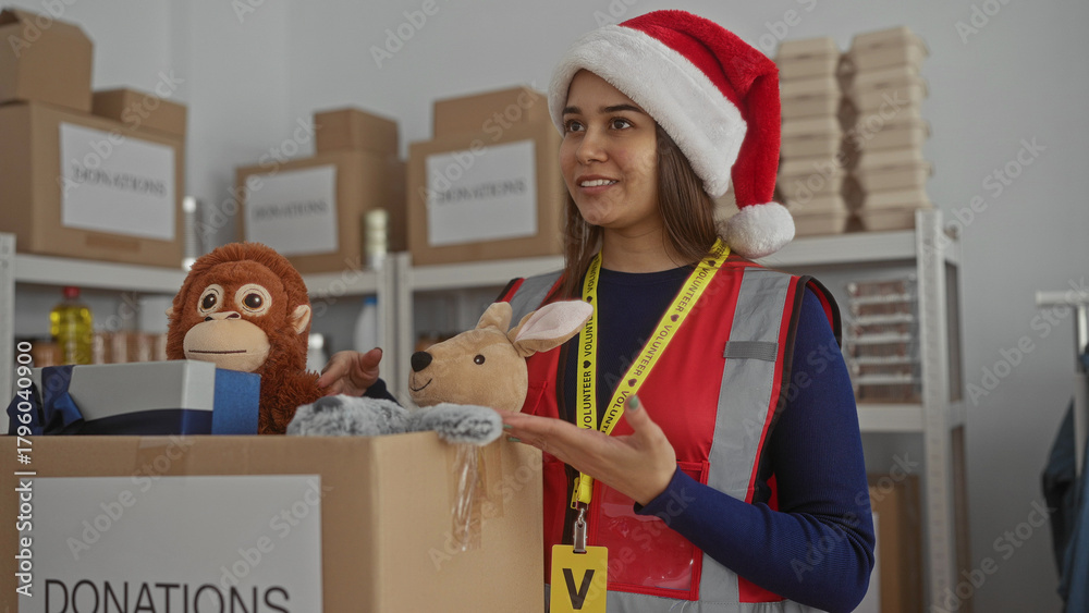 Obraz premium Woman organizing donations at charity center wearing santa hat sorting toys in festive indoor setting enhancing volunteer spirit and holiday joy helping community with generous contributions.