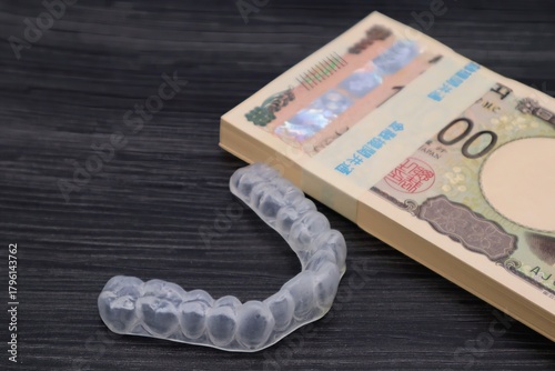 歯の矯正用のマウスピースと札束