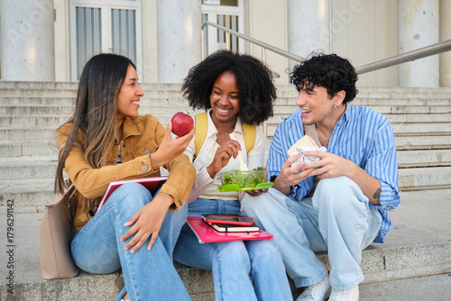 Diverse students eating lunch and laughing together on school steps