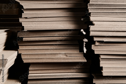 Slika na platnu Stacks of thick paperboard await transformation into durable cardboard boxes for