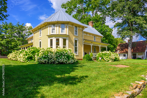 A stately yellow Victorian style home with hydrangea gardens in the rural village of Leiper's Fork, Franklin County Tennessee, on the National Register of Historic Places.