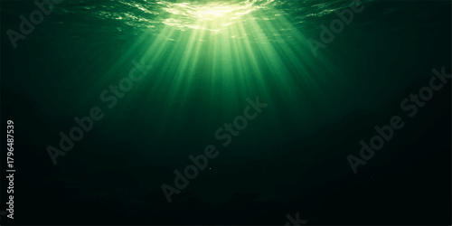 Bright sunlight rays beam through the blue water in a serene underwater ocean scene
