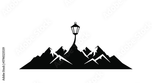 Iconic vintage lantern stands tall atop majestic mountain peaks under clear skies.