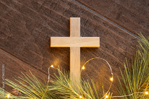 Close up cross with evergreen and mini lights