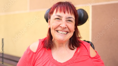 Woman with red hair smiling and happy in wheelchair outdoors