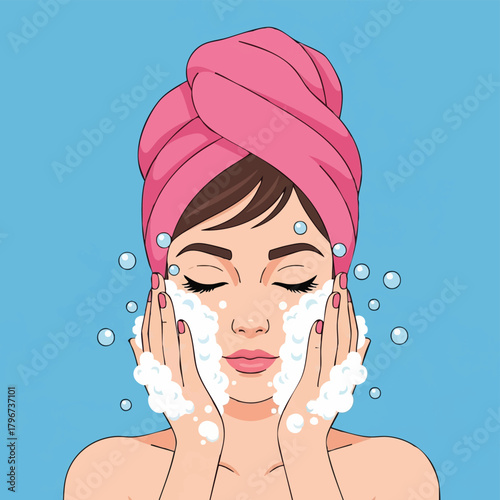 A woman with a pink towel on her head gently washes her face with foamy cleanser and water droplets against a blue background.