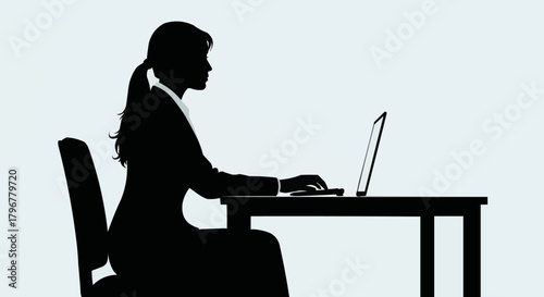Silhouette of a Woman Working on a Laptop at a Desk.