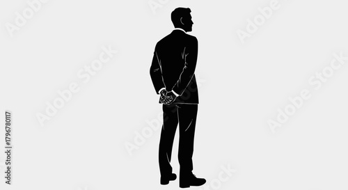 Silhouette of a man in a suit standing with hands behind his back.