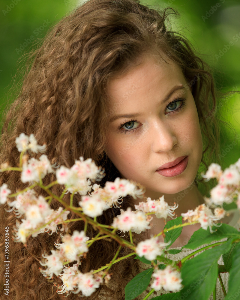 Fototapeta premium Portrait of beautiful young girl in park in spring