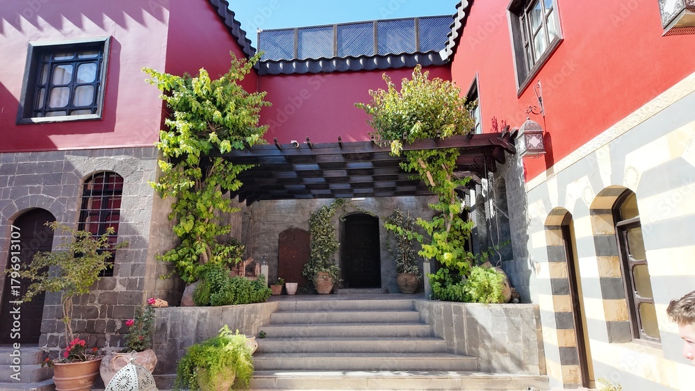 Fototapeta premium A charming view of the Talisman Hotel in Old Damascus, located in the historic Jewish Quarter. The traditional Arabic house features soft pink walls, classic courtyard architecture, and authentic Leva