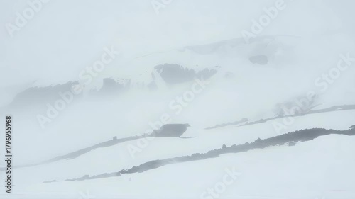 Snow-covered mountain peaks during a heavy blizzard or whiteout fog. 【Generative AI】
