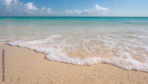 Fototapeta Naklejka Na Ścianę i Meble -  Sandy beach with tiding sea water and white wavelets, ideal for relaxation and leisure