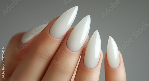 Elegant White Stiletto Nails Showcased on a Hand With a Smooth, Minimal Backg...
