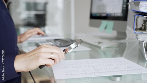 Wallpaper Mural Person auditing financial document using magnifying glass on desk with binders, researching business data. Audit and taxes in business Torontodigital.ca
