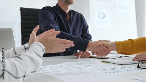 Business partners engaging in a handshake following a successful meeting, solidifying a business deal or contract in a sleek, modern office environment
