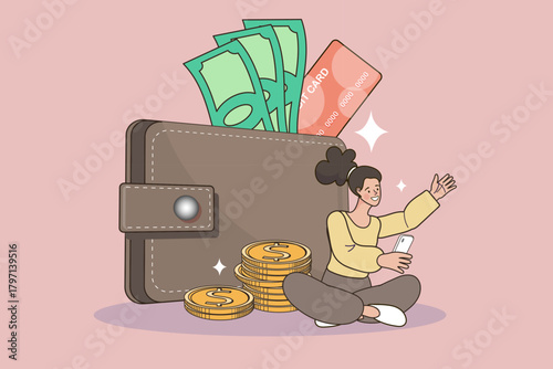 Achieve financial security with this personal savings concept. A happy woman sits next to a giant wallet full of cash and coins, managing her budget and banking on a smartphone app.
