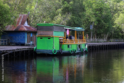 Klotok houseboat is a traditional wooden boat with a bed, kitchen and bathroom for cruising along the Sekonyer River, Tanjung Puting National Park, Kalimantan, Indonesia                               
